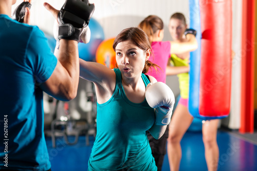 Female kick boxer with trainer in sparring © Kzenon