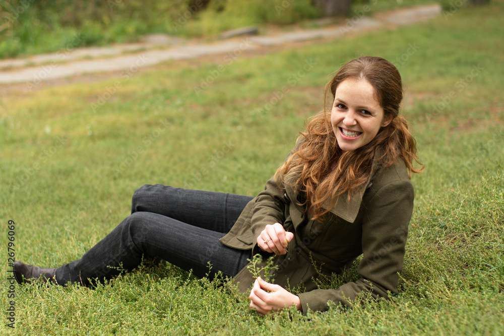 Fototapeta premium Redhead woman lie on the grass