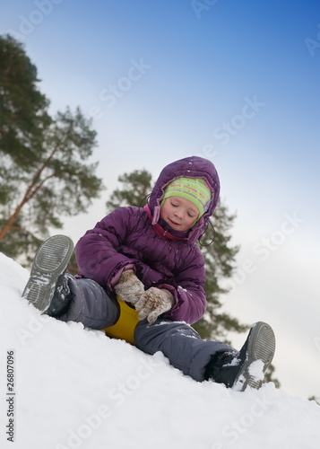 child sliding in the snow