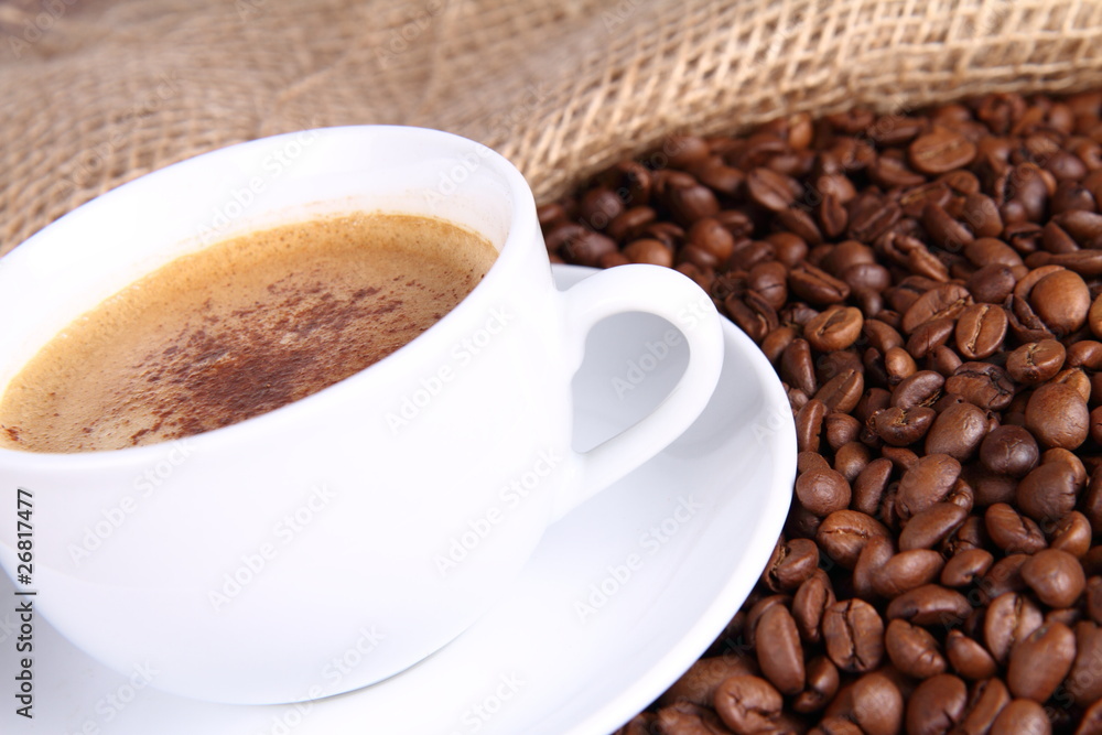 Cup of coffee with cinnamon,coffee beans and burlap material Cup of coffee with cinnamon,coffee beans and burlap material