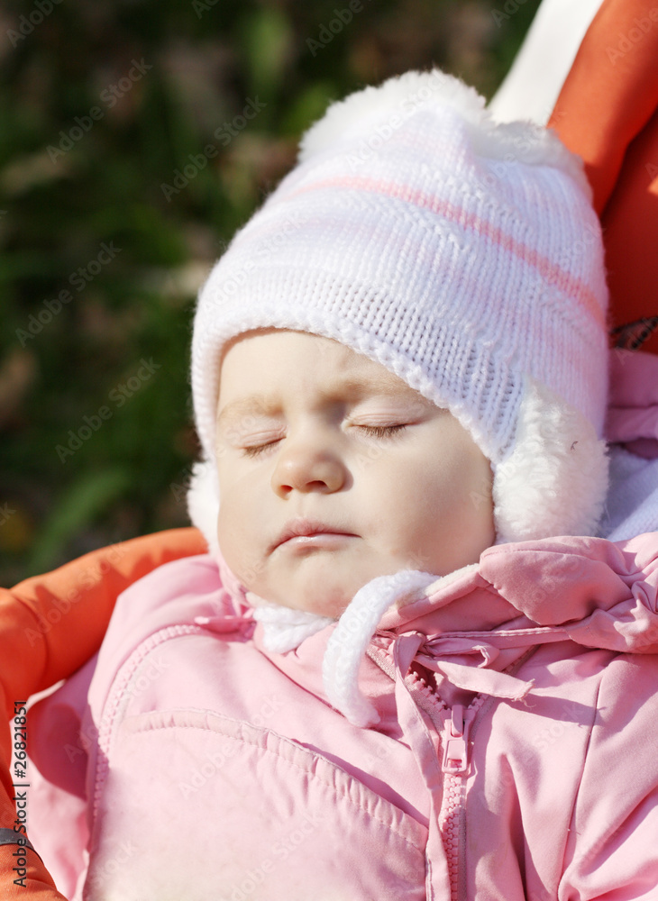little girl in a pink jacket sleeps in a carriage little girl in a pink jacket sleeps in a carriage