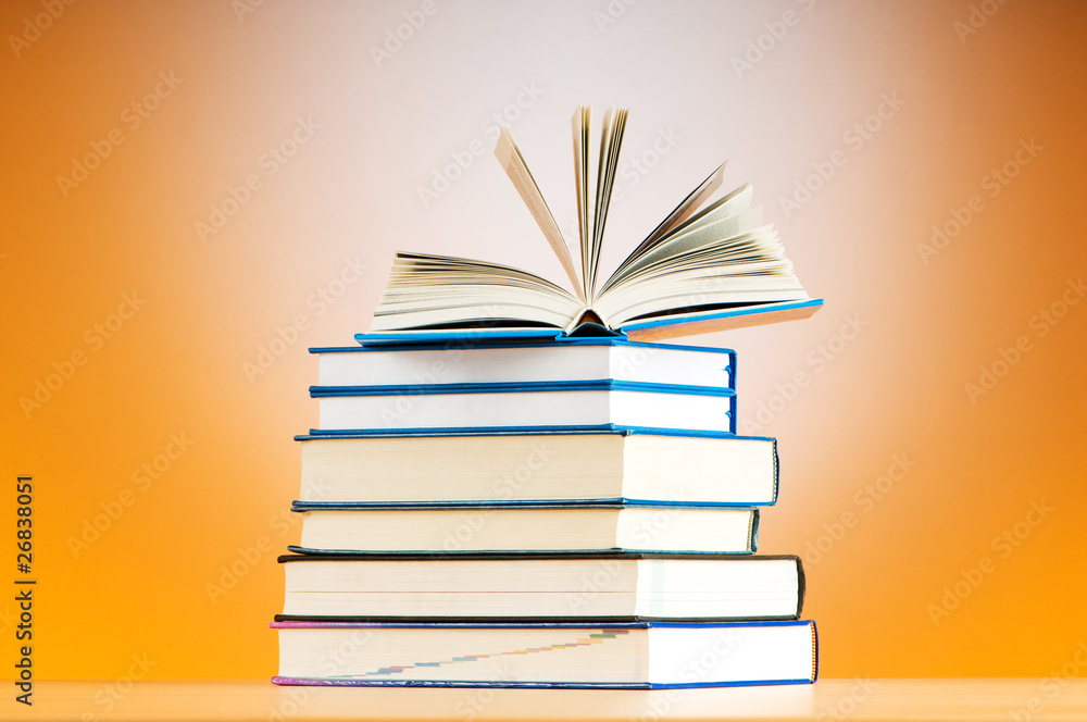 Fototapeta premium Stack of text books against gradient background