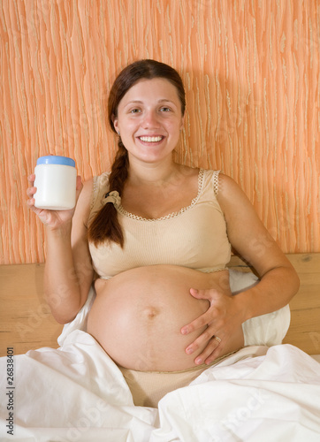 Pregnant woman with body cream photo