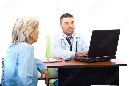 Doctor using laptop and having patient visit