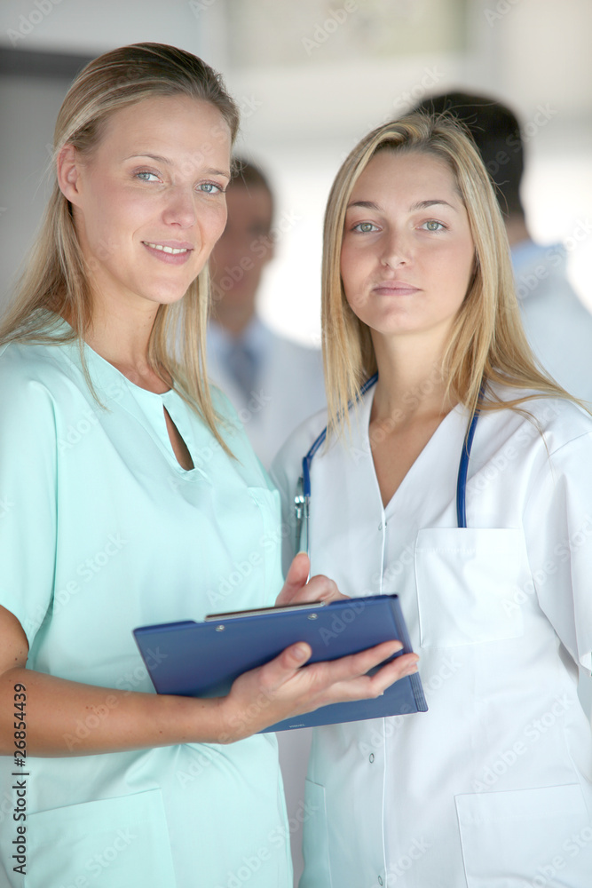 Beautiful nurses standing in hospital corridor Beautiful nurses standing in hospital corridor