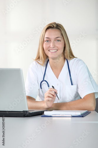 Beautiful smilng nurse working in the office