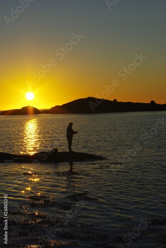 Fototapeta Naklejka Na Ścianę i Meble -  Fisherman silhouettes against sunset