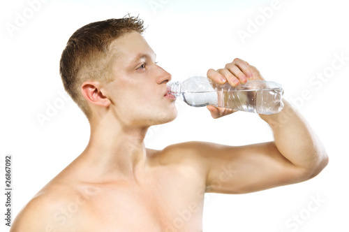Handsome muscular male drinking water