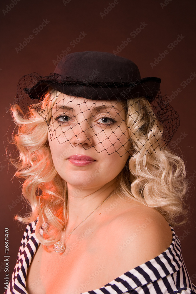Portrait of beautiful young woman in a black hat with a veil
