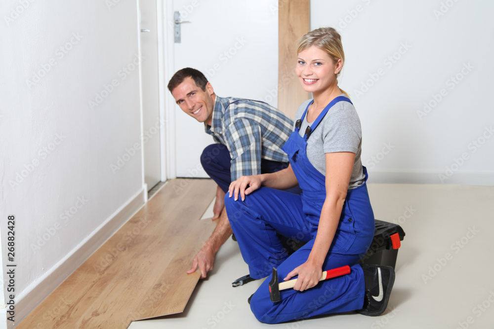 Closeup of artisan installing flooring in room Closeup of artisan installing flooring in room