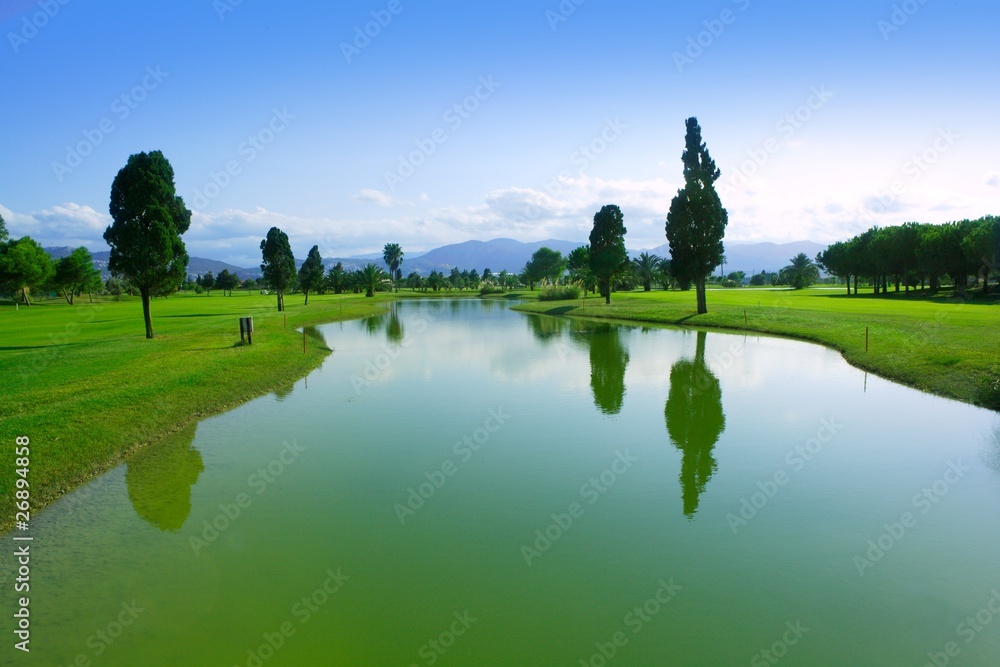 Fototapeta premium Golf course green grass field lake reflection