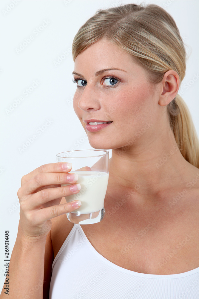 Beautiful blond woman holding glass of milk Beautiful blond woman holding glass of milk