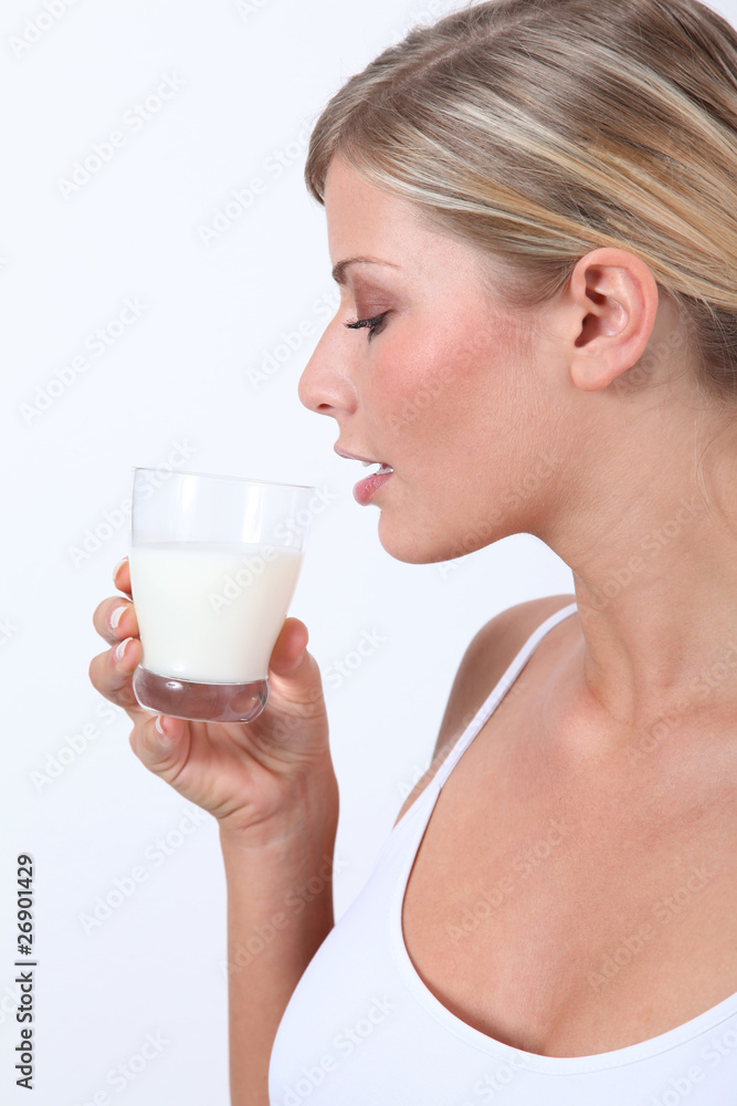 Beautiful blond woman holding glass of milk Beautiful blond woman holding glass of milk