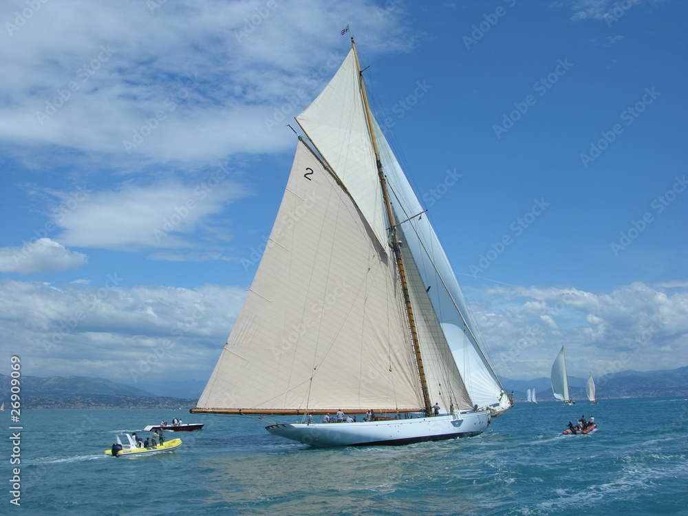 Classic wood yacht in regatta with white sails blue sky and sea