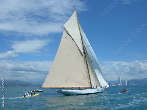 Classic wood yacht in regatta with white sails blue sky and sea