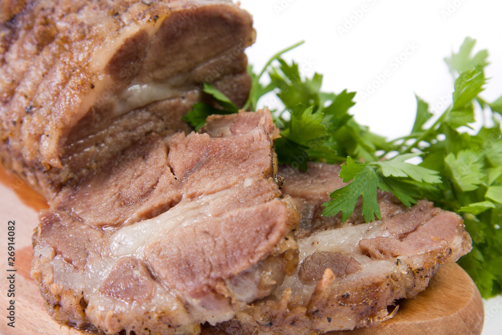 Appetizing piece of roasted meat on a wood piece with parsley Appetizing piece of roasted meat on a wood piece with parsley