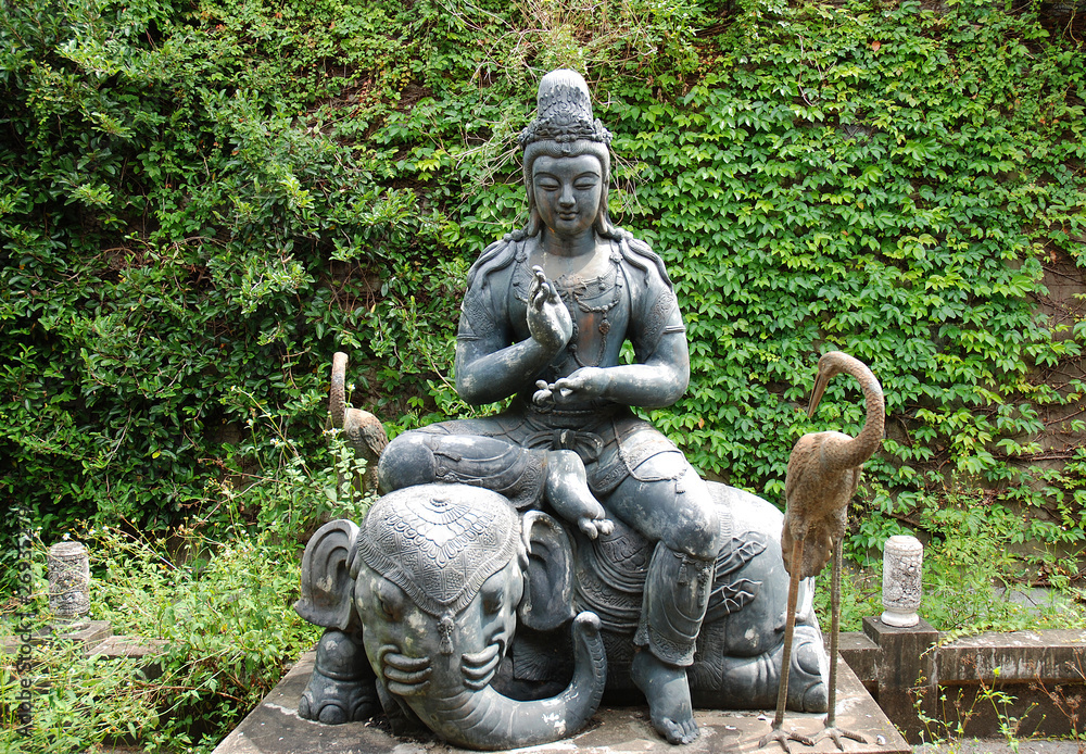 Buddhistische Figurengruppe auf Elefant im Tempelgarten