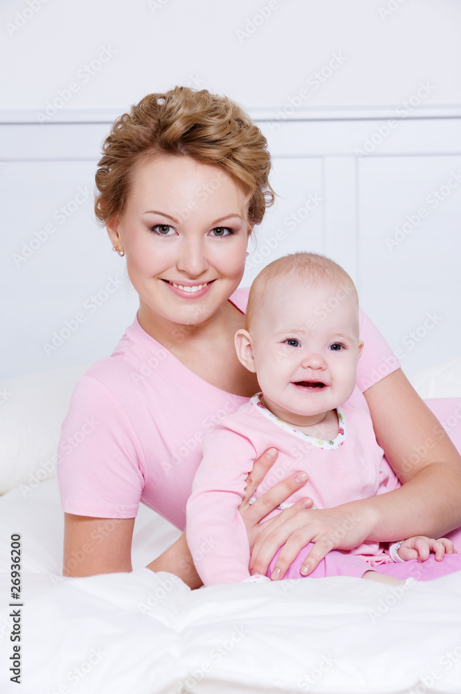 attactive mother lying with her baby on the bed attactive mother lying with her baby on the bed