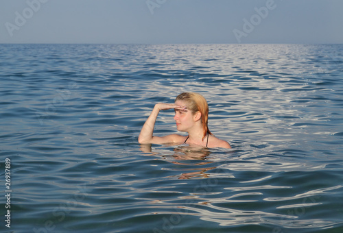 Beautiful young girl looking from water