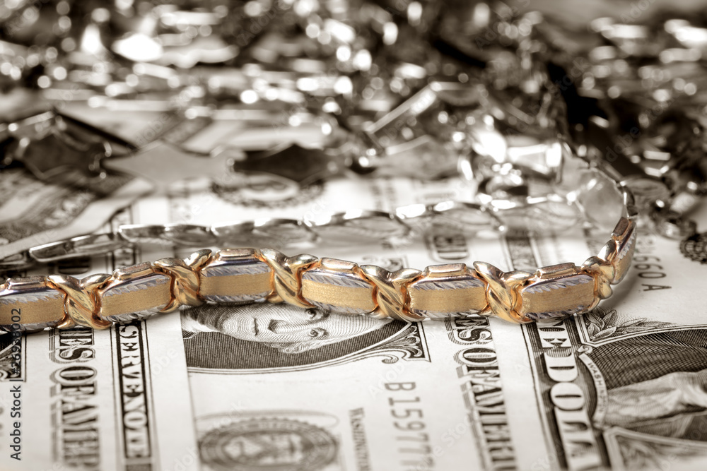 Golden bracelet and other jewelry at money background Golden bracelet and other jewelry at money background
