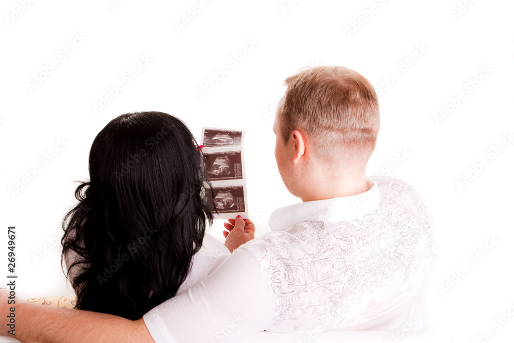 beautiful young couple holding a sonogram of their unborn child. beautiful young couple holding a sonogram of their unborn child.