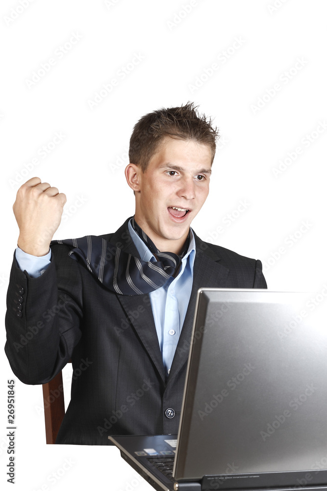 young man in a suit sitting next to laptop young man in a suit sitting next to laptop