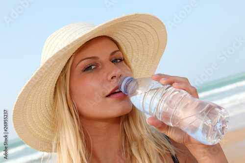 Closeup of woman drinking water at the beach