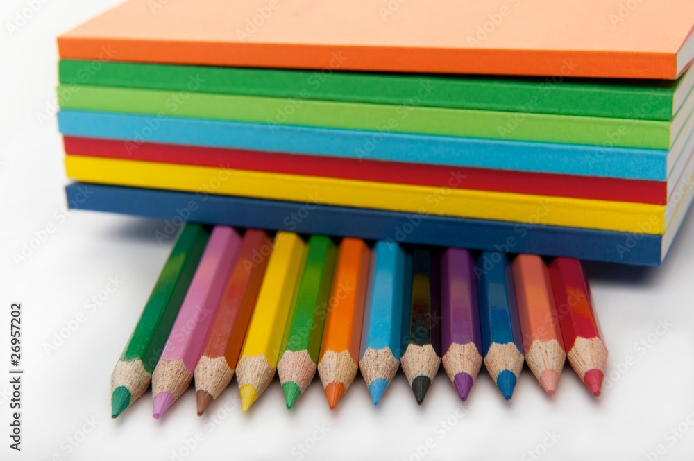 row of pencils under stack of books row of pencils under stack of books