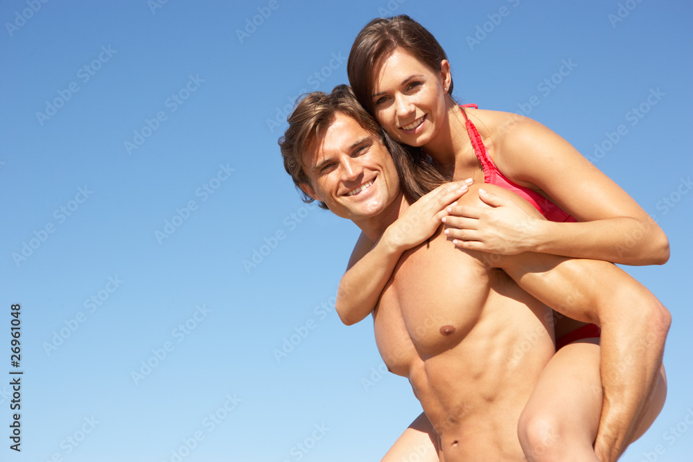 Young Couple Enjoying Piggyback On Beach Holiday Young Couple Enjoying Piggyback On Beach Holiday