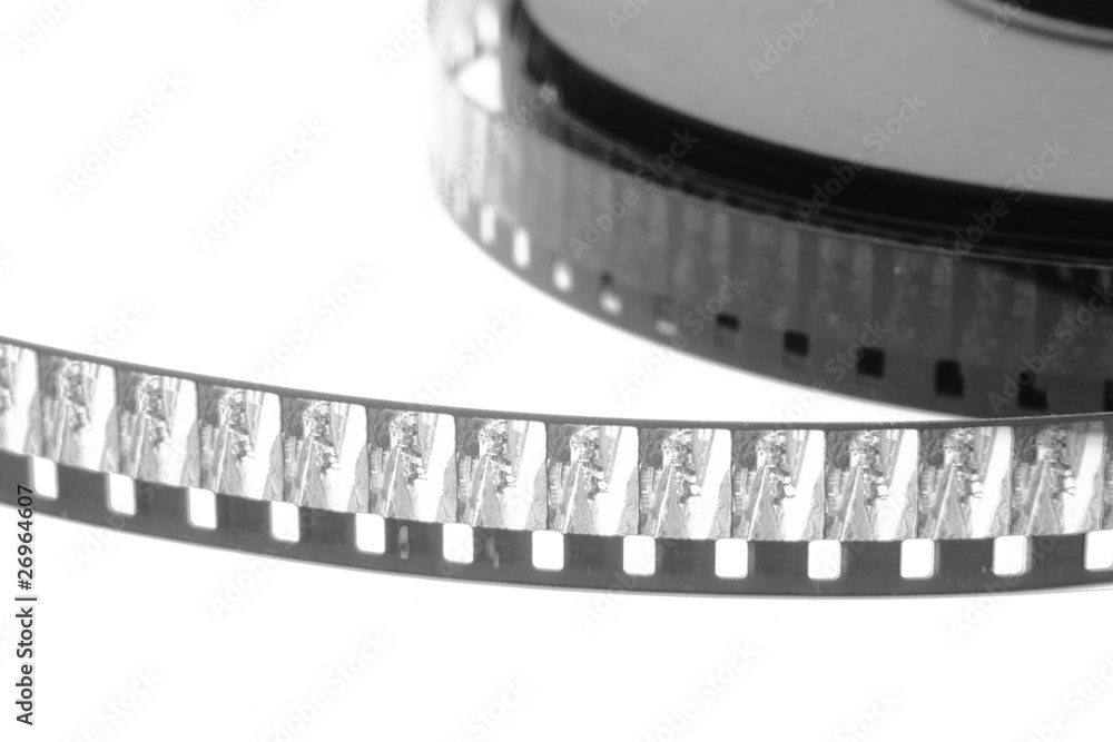 stack of old movie film on plastic reel on white