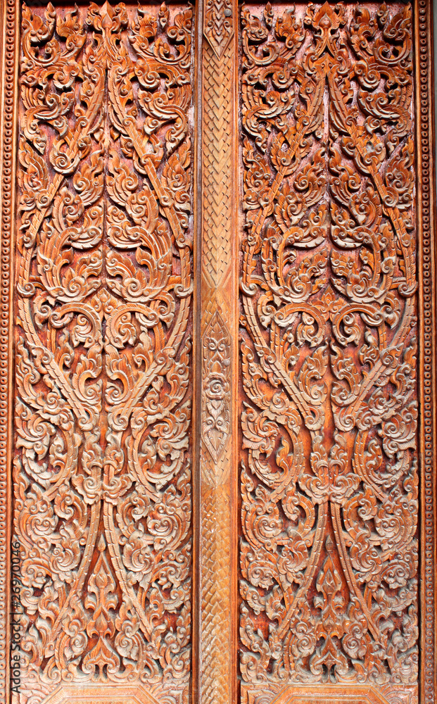 Thai art wood carving on door of temple