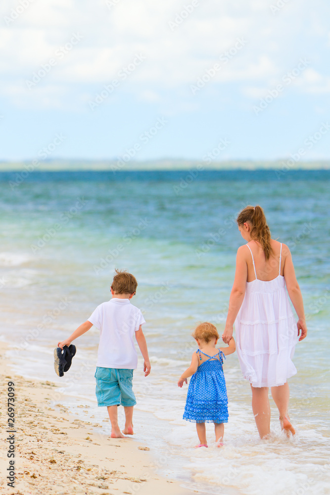 Family walking along tropical beach