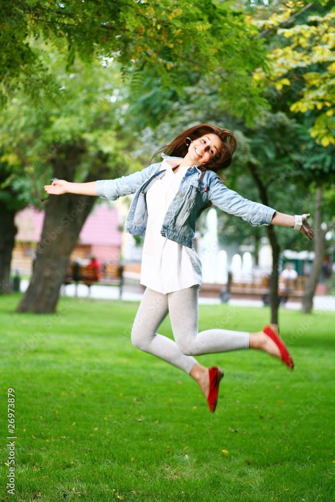 young woman jamping on a grass