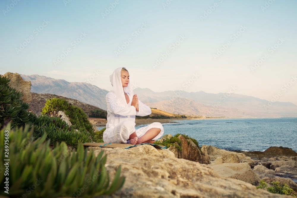 Beautiful woman doing yoga exercise outdoors
