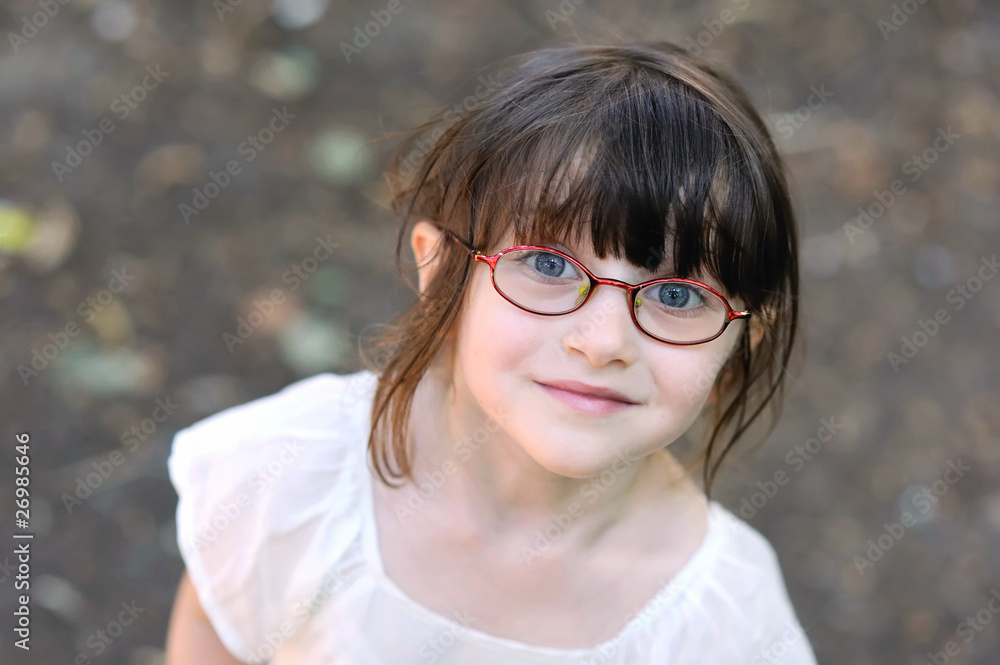 Adorable toddler girl in glasses looking to the camera Adorable toddler girl in glasses looking to the camera
