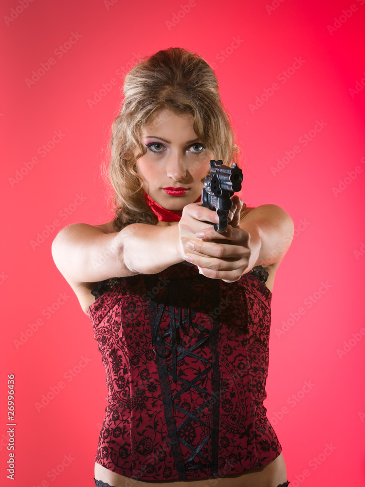 Beauty girl with revolver against a red background Beauty girl with revolver against a red background