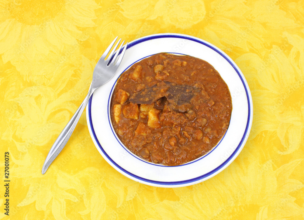 Chickpea masala on yellow cloth background with fork Chickpea masala on yellow cloth background with fork