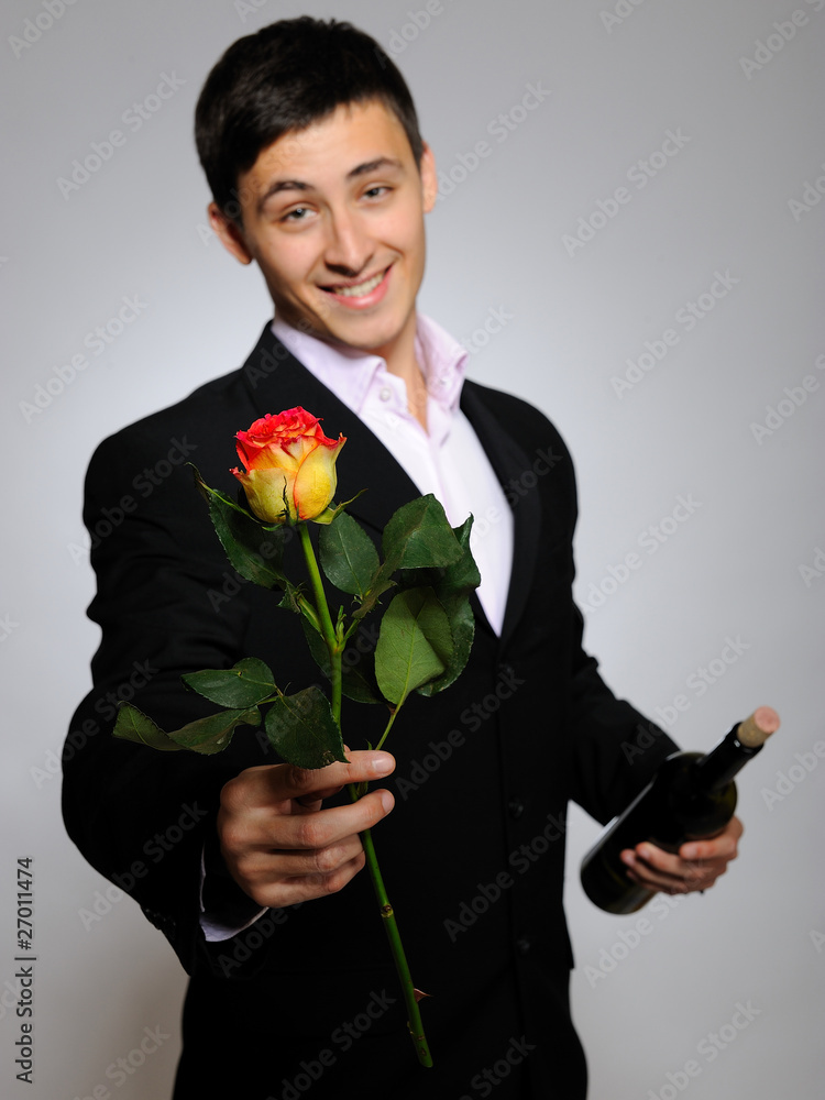 Handsome romantic young man holding rose flower and vine bottle Handsome romantic young man holding rose flower and vine bottle