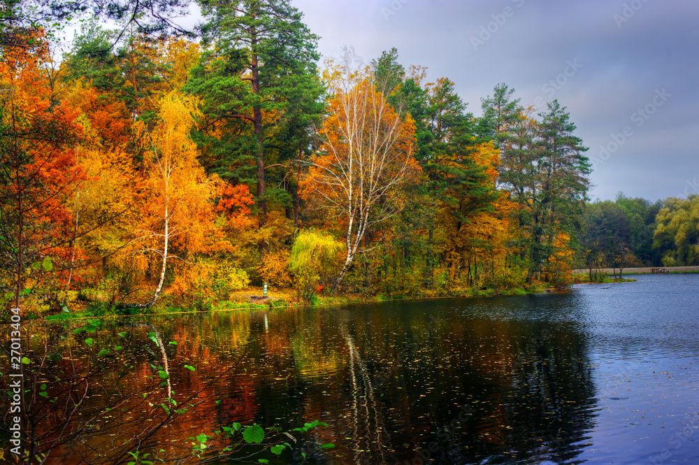 Picturesque autumn landscape of lake and bright trees and bushes