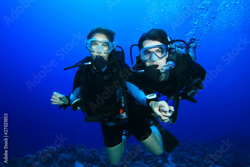 Couple scuba diving on a coral reef