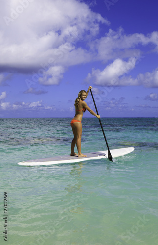 teenage girl in bikini on a paddle board in hawaii