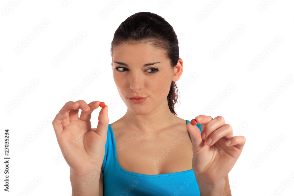 Junge Frau prüft zwei Tabletten Junge Frau prüft zwei Tabletten