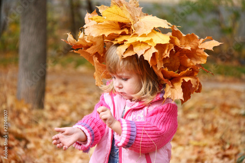 Little girl in autumn orange leaves. Outdoor.