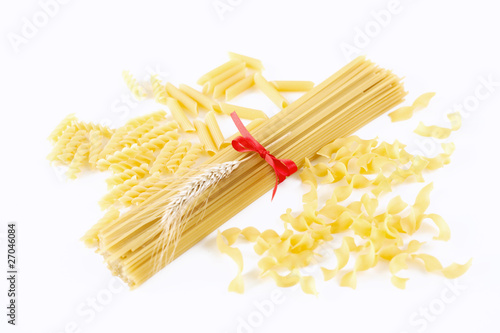spaghetti tied with a bow and other pasta on white