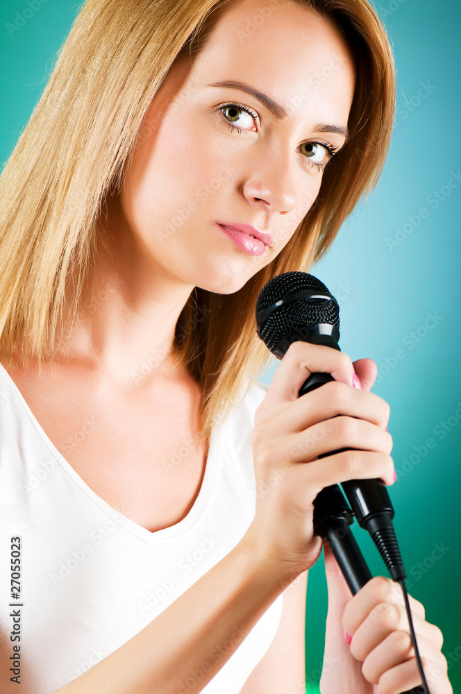 Girl singing with microphone against gradient background Girl singing with microphone against gradient background