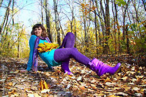 Young girl lying in the autumn fall leaves