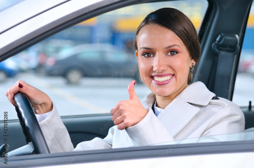 happy woman is showing a thumb from a car