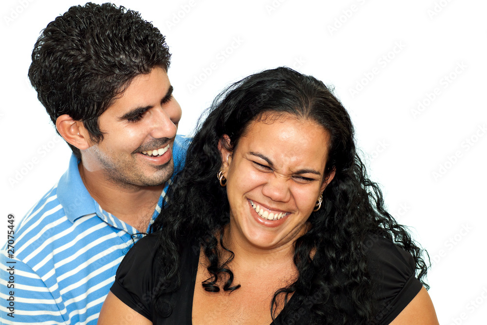 Young latin couple hugging and laughing on a white background Young latin couple hugging and laughing on a white background