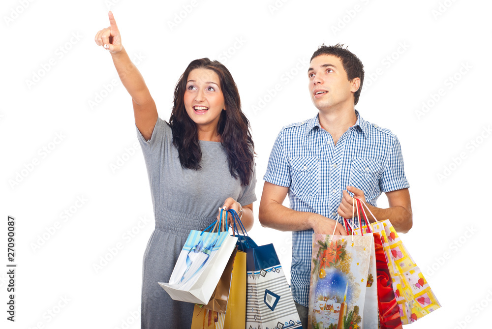 Fotografie Surprised couple at shopping pointing up