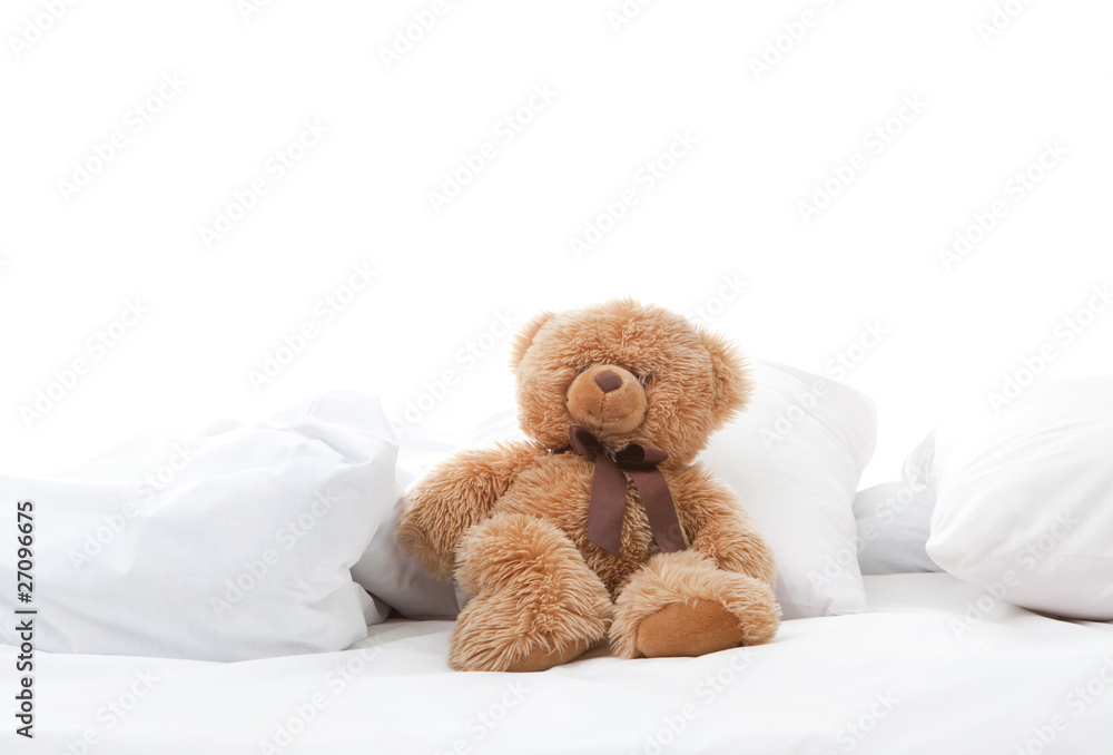 fun teddy bear sitting on bed